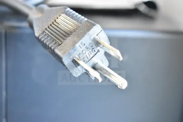 A close-up of a power plug, labeled as "Kord King," connected to the Nemco 6016 Carving Station.