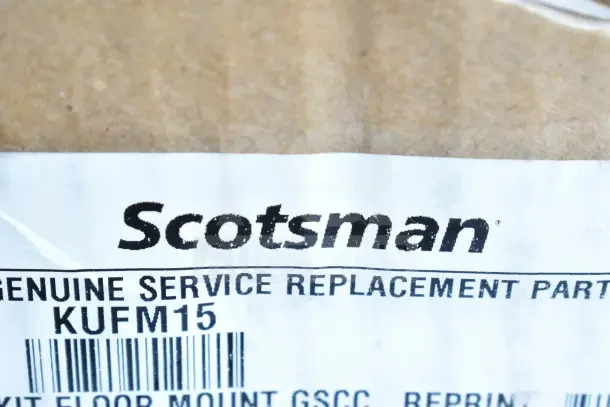 "Scotsman KUFM15 Floor Mount Kit label, showing model number and barcode, brand new with scratch and dent condition."
