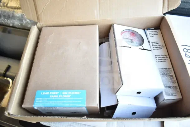 Boxed lot containing a brand new Watts LFN250B-Z2-020 iron body water pressure regulator, labeled lead-free.