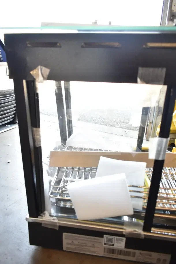 Brand new Avantco 177HDC26 heated display case, 26", 3 shelves, sliding doors. 120V, 1 phase. Minor scratches and dents visible.