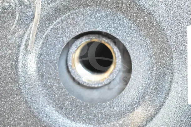 Close-up of a part on a ServIt 423EST2WS Mini-Compact Electric Booster Water Heater, showing metallic textured surface.