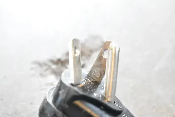 "Close-up of three-prong plug for a Cadco commercial microwave oven. Plug shows slight wear, indicating '10C'."