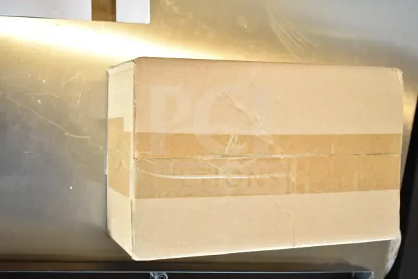 Cardboard box containing a brand new, scratch-and-dent popcorn cart. Box shows wear.