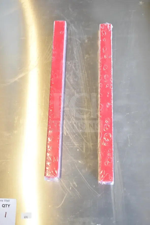 Two red, packaged metal beams on a reflective surface, part of a new "Scratch and Dent" popcorn cart. Label indicates quantity 1.