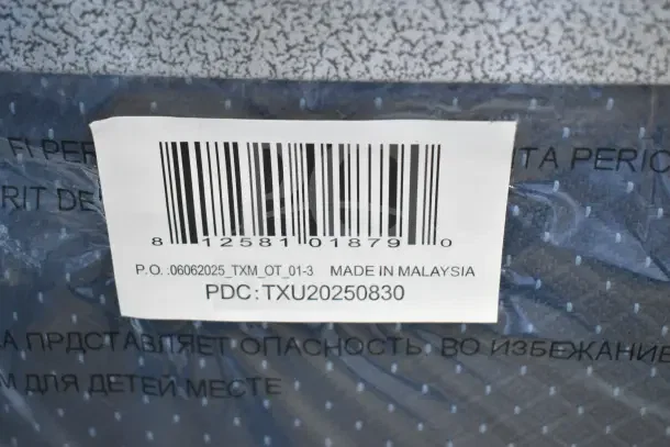 Barcode with item number P.O.:06062025_TXM_OT_01-3, "Made in Malaysia" label on scratch and dent banquet chair packaging.