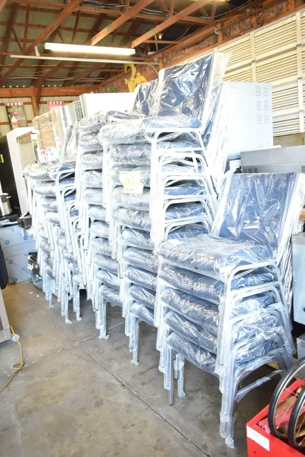 44 stackable banquet chairs, scratch and dent condition, wrapped in plastic, metal frames, blue cushions.