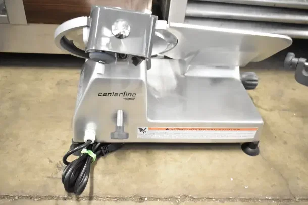 BRAND NEW Hobart Centerline EDGE10-11 manual meat slicer with 10" blade, built-in sharpener, 115V, 1 Phase. Slight scratches.