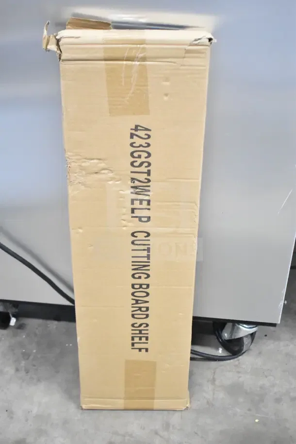 Cardboard box labeled "423GST2WELP Cutting Board Shelf" for ServIt steam table. Box shows minor wear indicative of storage.