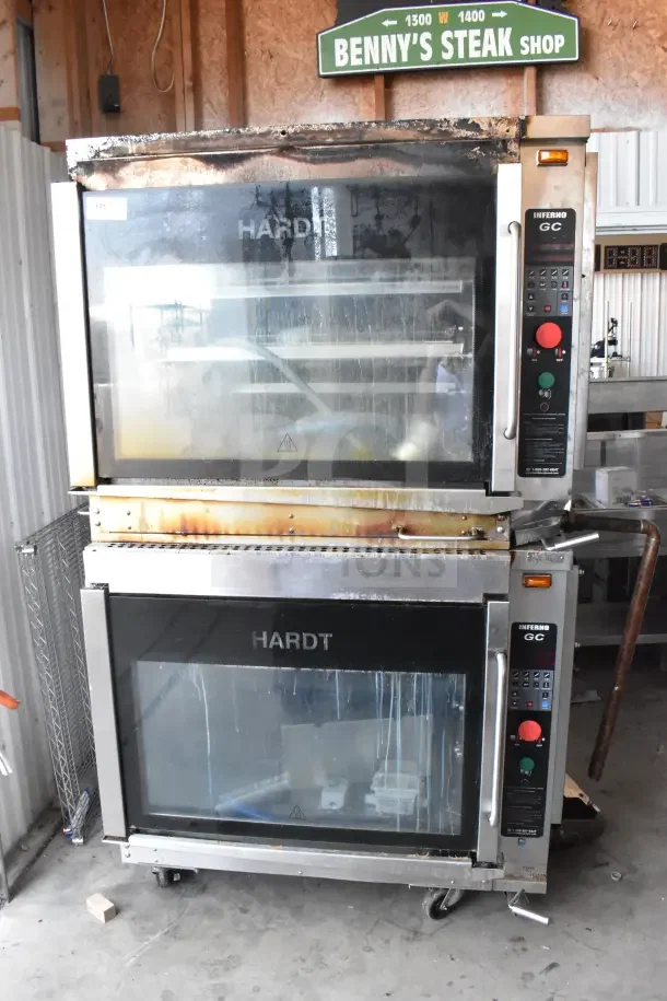Two Hardt Inferno GC/4000 rotisserie ovens on casters, natural gas-powered, 68,000 BTU, commercial use, visible wear.