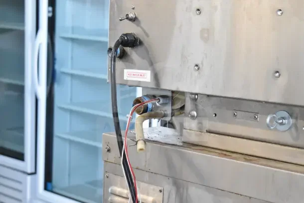 Hardt Inferno GC/4000 commercial rotisserie oven, natural gas powered, on casters, 68,000 BTU, hot water inlet visible.