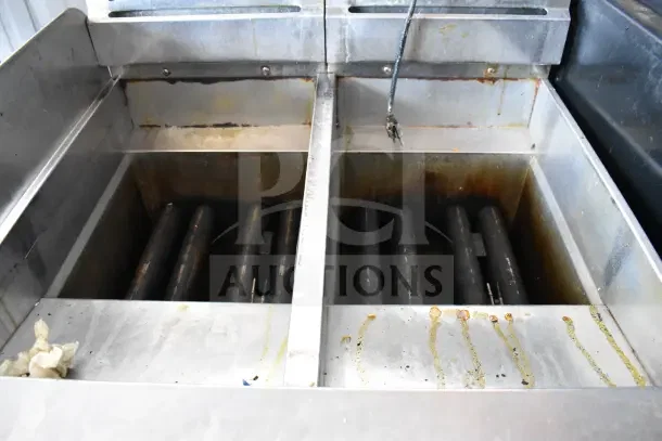 Pitco Frialator Commercial Gas 2-Bay Deep Fat Fryer on casters, shows signs of use with visible oil stains and wear.