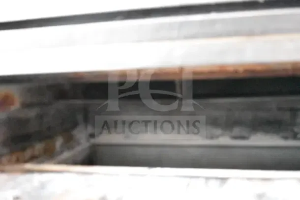 Bakers Pride single deck gas pizza oven on metal legs, showing interior. Used condition with visible rust and wear.