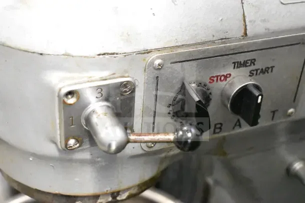 Hobart A200 20 Quart Dough Mixer control panel, showing speed lever and timer dial. Visible wear on metal surfaces.