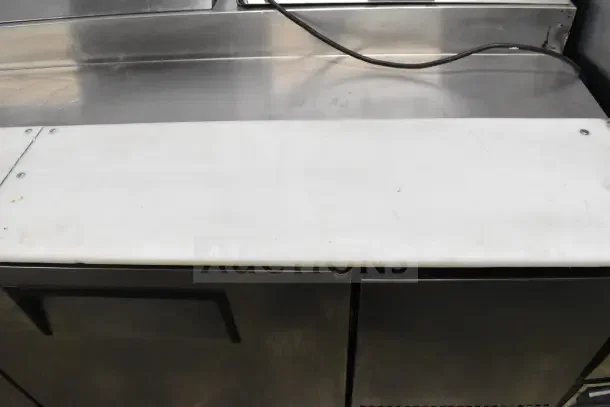 True TPP-67 commercial pizza prep table, stainless steel, with cutting board, on commercial casters. 115 volts, 1 phase.