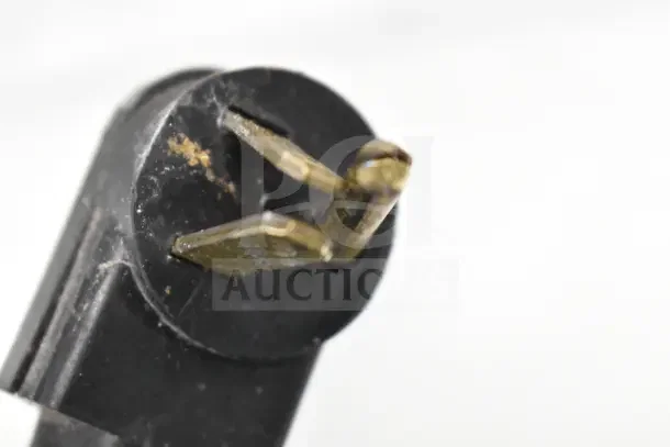 A close-up of a worn, two-prong electrical plug on the True TPP-67 Commercial Pizza Prep Table, 115 volts, 1 phase.