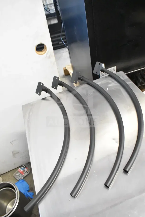BRAND NEW SCRATCH AND DENT Bighorn 24" Mini Ranch Fire Pit parts; curved metal pieces on a surface.