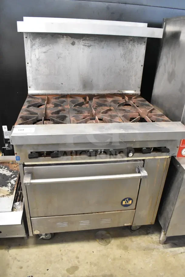 US Range commercial gas-powered 6-burner range with oven, over shelf, back splash, and commercial casters in used condition.