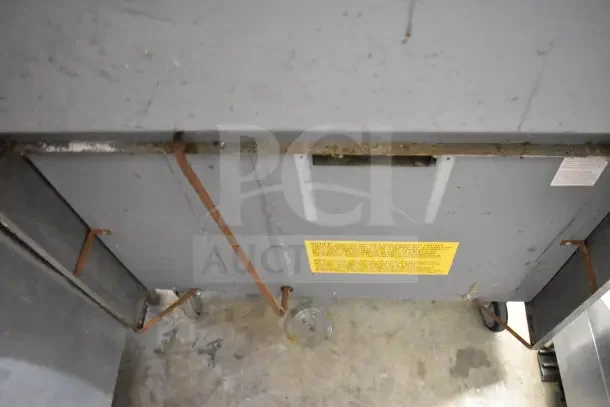 US Range commercial gas 6-burner range with oven, overshelf, backsplash, on casters; visible underside label with specs.