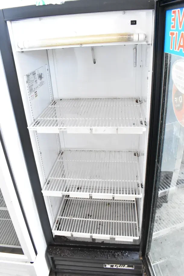 True GDM-12 Commercial Single Door Cooler, 115V, 1 Phase. Features glass door, white wire shelves, good condition. Model label visible.