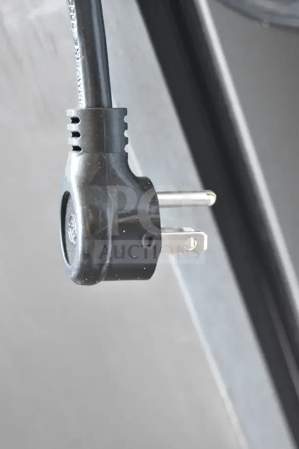 Close-up of a plug for a 2021 True TSCI-600R-G-PH commercial cooler, showing a standard three-prong design.