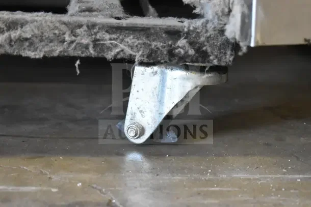 2016 True T-35 commercial cooler caster, showing signs of wear and dust accumulation.