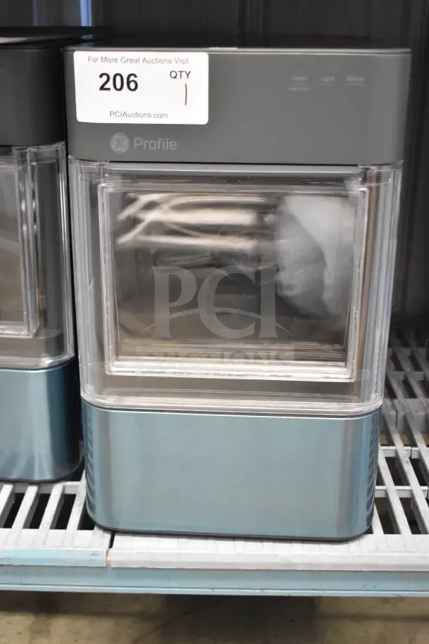 General Electric GE XPIO13SCESS countertop ice maker; clean design, transparent window, 120 volts, auction tag visible.