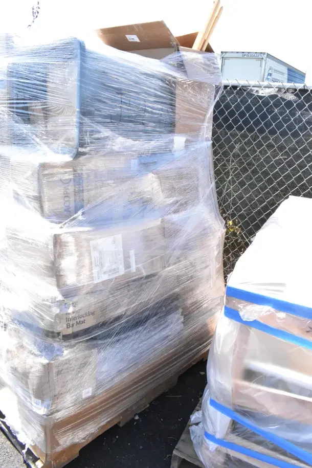 Pallet of 26 new scratch and dent items, including a bar mat and airpot, wrapped in plastic. Markings visible on packaging.