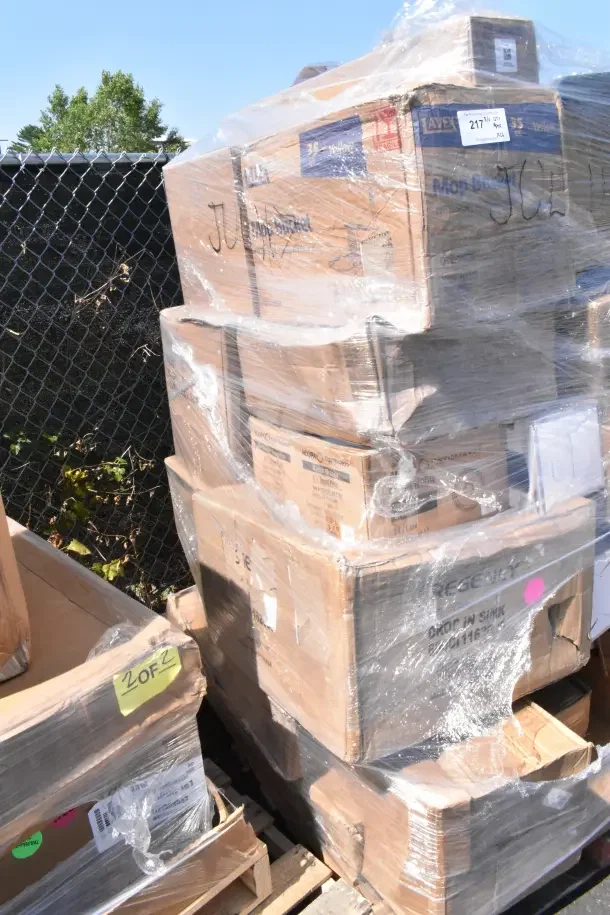 Stack of 26 brand new scratch and dent items on pallets, shrink-wrapped. Labels include Regency Drop-In Sink and various codes.