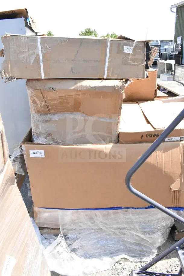Boxes of 5 brand new scratch and dent items, including a black Lancaster Table & Seating folding chair with vinyl seat.