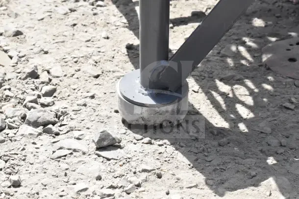 Close-up of the base of a Tri-Arc steel mobile work platform leg. Visible scratches and dents; heavy-duty construction.