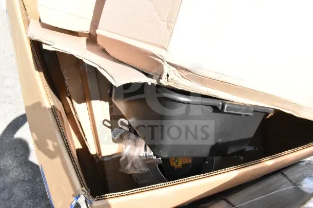 Cardboard box containing new scratch and dent items, including a black plastic bin, visible under partially open lid.