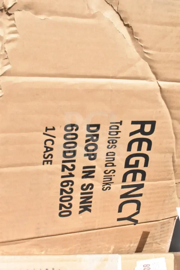 Cardboard box labeled "Regency Tables and Sinks, Drop In Sink, 600DI2162020, 1/Case" with visible creases and dents.