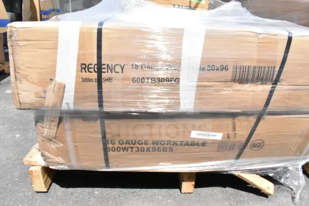 Stacked boxes of Regency 18-gauge worktable 30x96, model 600TB3096G, on a pallet, wrapped in plastic.