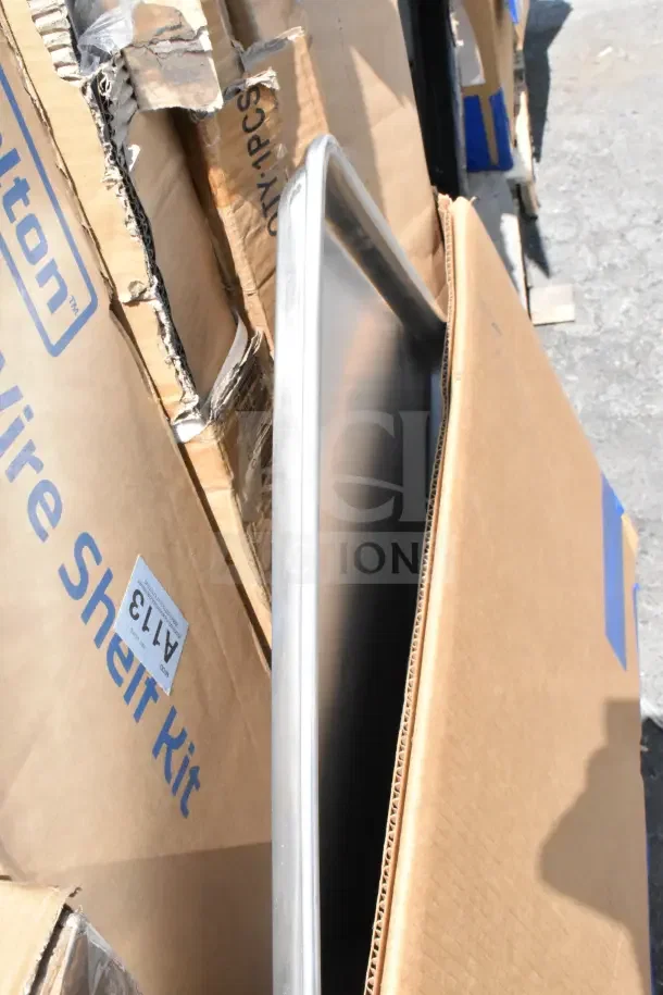 Cardboard boxes containing a mix of 12 new scratch and dent items, including an AvaMix tilting blender. Some boxes are visibly damaged.