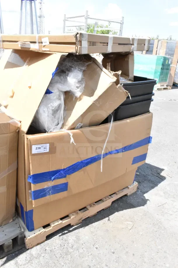 Large cardboard box on pallet with mixed items, including tabletops and black trash cans. Label shows "QTY X15." Scratch and dent condition.