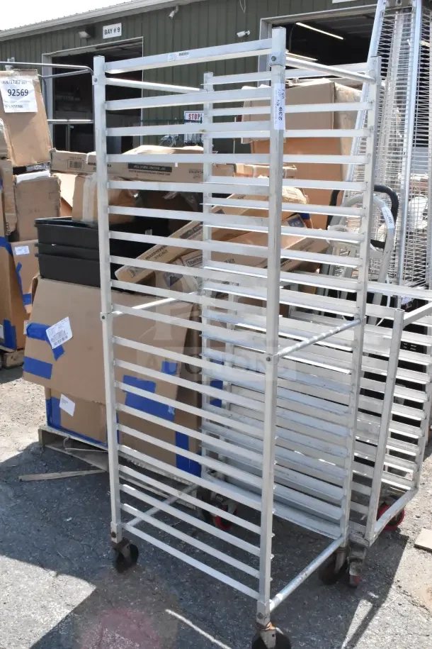 Two commercial pan transport racks with multiple shelves, metal construction, on casters. Tags show lot number 92569.