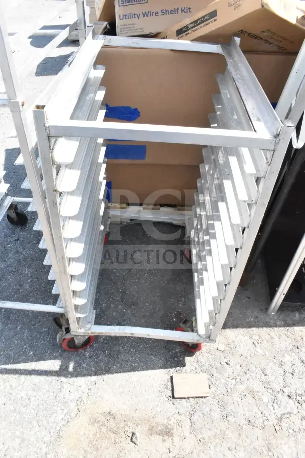 2 commercial pan transport racks with multiple slots, metal construction, caster wheels; some signs of wear.