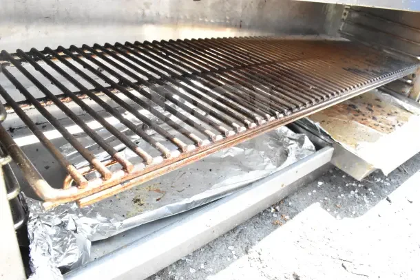 Southbend commercial gas-powered cheese melter with grill and tray, showing used condition with visible residue.