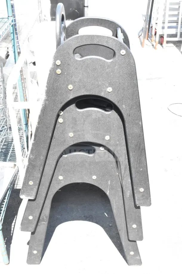 Three stacked Koala Kare high chairs, black, with durable build; show minor wear. Durable, practical, ideal for businesses.