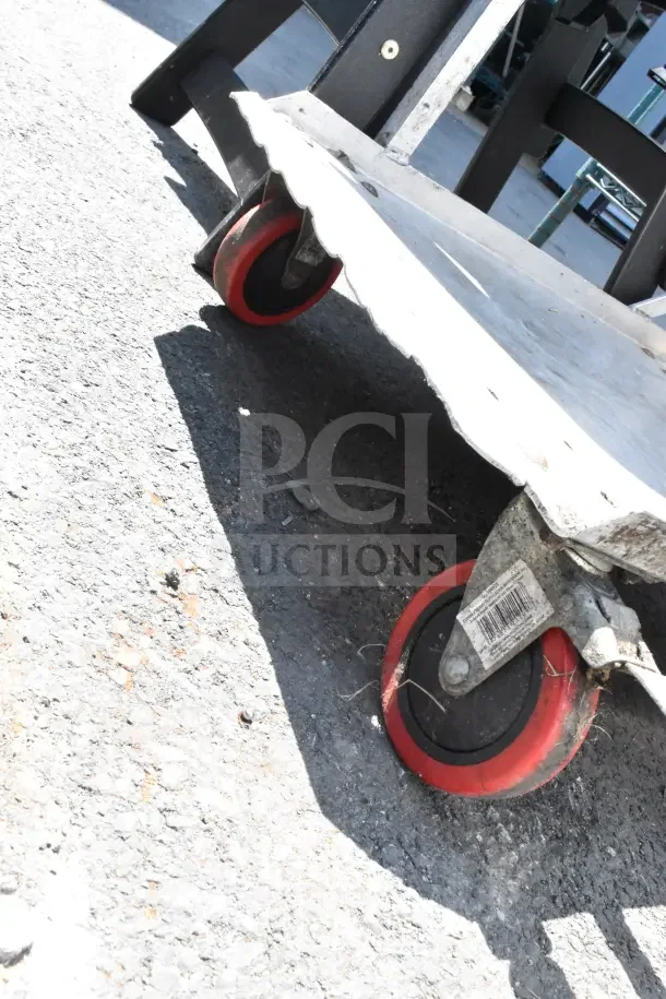 Commercial cart with red commercial casters, showing wear on metal surfaces. Visible barcode sticker on caster.
