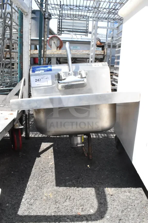 Commercial single bay wall mount sink with faucet and handles, stainless steel, good condition, includes plumbing fixtures.