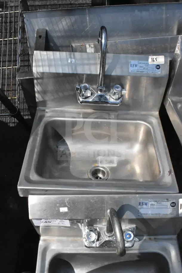 Two commercial single bay wall mount sinks with faucets and handles, stainless steel, used condition, labeled "RSW" and "NSF."