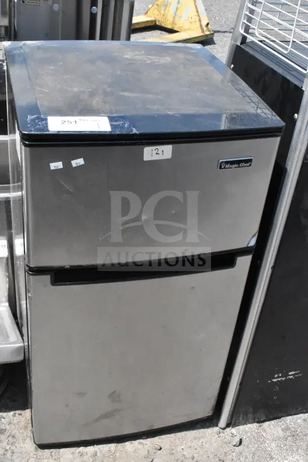 Magic Chef HMDR310SE Mini Cooler with Freezer, stainless steel, visible dents, 120 Volts, 1 Phase, model label shown.