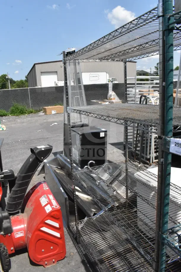 Chrome finish 4-tier wire shelving unit, outdoor setting. Buyer must dismantle for shipping considerations.