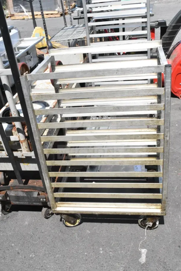 Commercial pan transport rack on casters, metal frame, used condition, ideal for kitchen or bakery use.