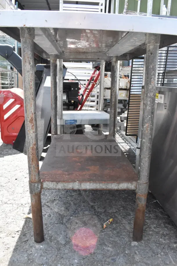 Stainless steel commercial table with under shelf. Features rusted legs, robust construction, and additional storage shelf.