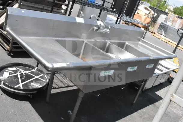 Stainless steel commercial 3 bay sink with dual drain boards, labels for wash, rinse, sanitize, in good condition.