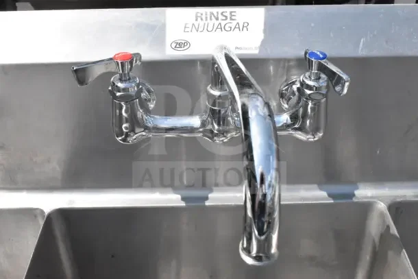 Commercial 3 bay sink with dual drain boards, chrome faucet, labels "Rinse/Enjuagar", Zep brand, excellent condition.