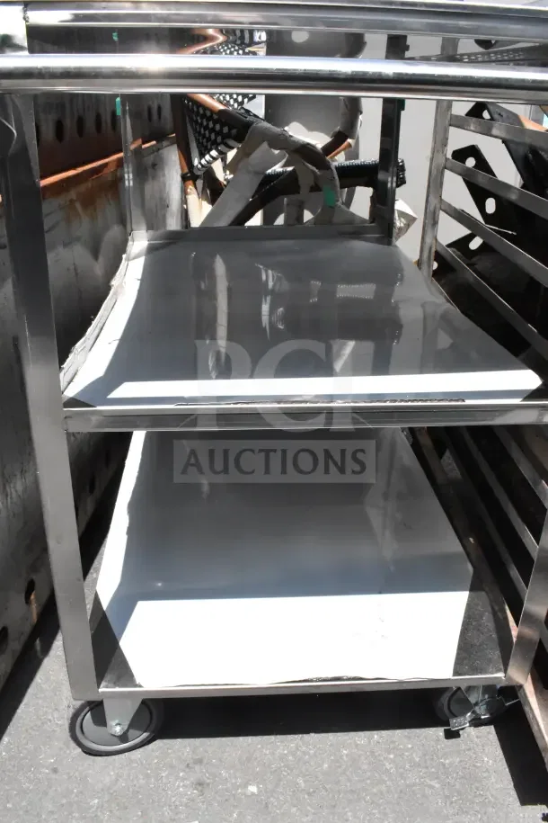 Commercial 3-tier stainless steel cart with durable commercial casters. In good condition, ideal for heavy-duty use.