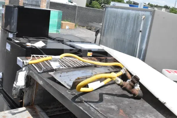 2 Bakers Pride commercial gas pizza ovens, single deck, showing wear. Includes gas lines and metal racks.